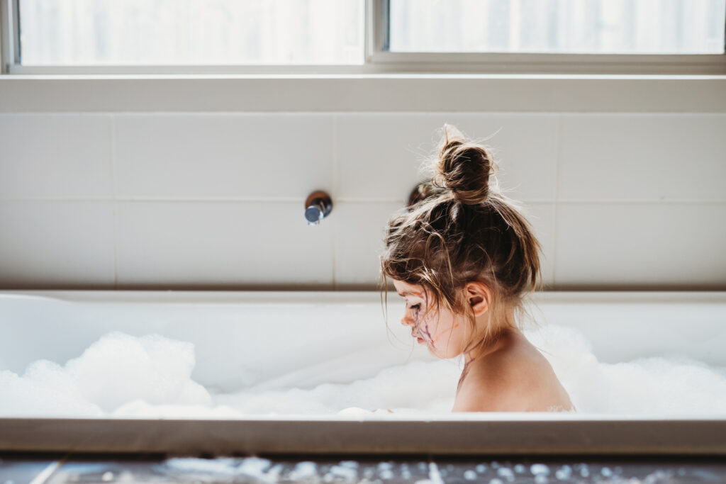GIrl in bath, face covered in texta