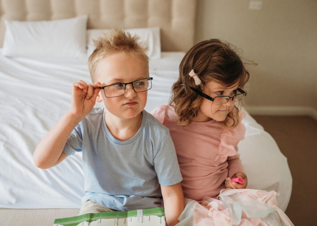 Children wearing their dad's glasses during a family photoshoot.